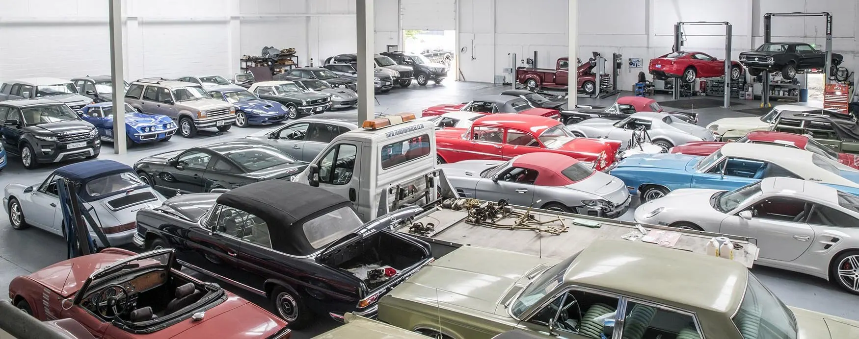 Busy ShipMyCar workshop with technicians working on imported cars