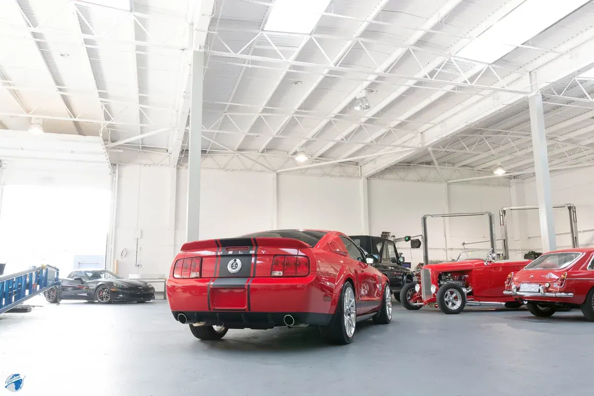 Rear view of a red Shelby Super Snake in the ShipMyCar workshop