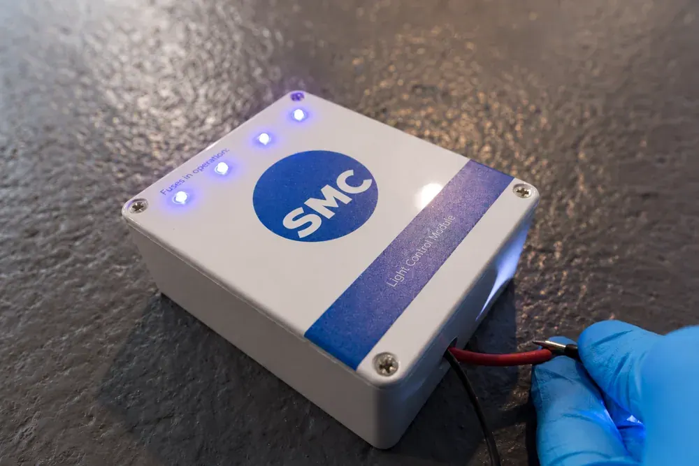 SMC light control module with illuminated status lights on a workshop bench