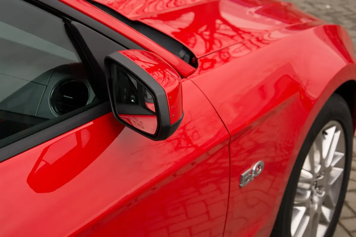 Three discreet indicator lights in a red Mustang wing mirror, switched off