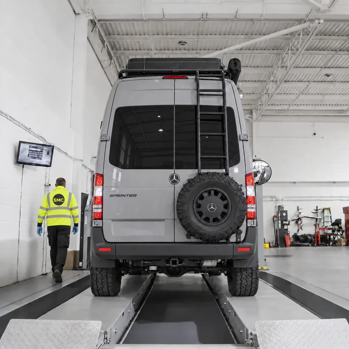 Mercedes-Benz Sprinter campervan on a vehicle testing lane beside a technician